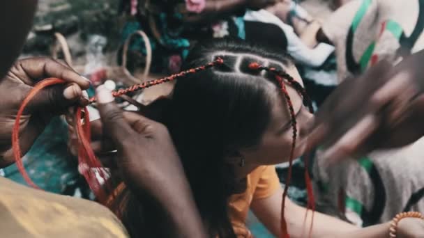 Proceso de tejer trenzas africanas con Kanekalon rojo al aire libre, Zanzíbar, África — Vídeos de Stock