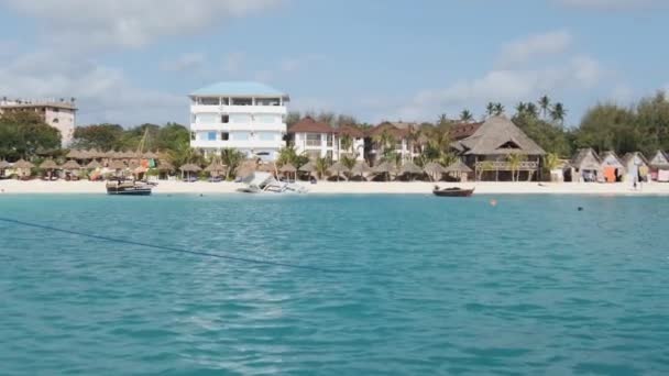 サンディビーチ、パーム、ホテルとZanzibar海岸線。フローティングボートからの眺め — ストック動画