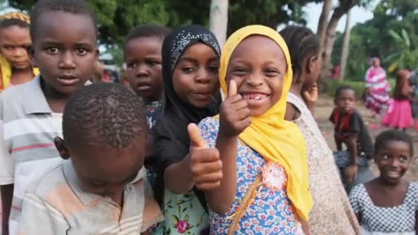 Счастливые местные африканские дети показывают пальцем вверх знак и любопытный вид деревни Занзибар — стоковое видео
