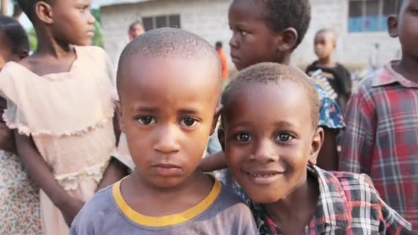 Chicos africanos locales curiosos mirando a la cámara en la aldea de Zanzíbar, África — Vídeo de stock