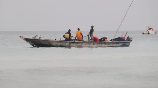 Afričtí rybáři na dřevěné lodi Ryby v oceánu pomocí rybářské sítě, Zanzibar — Stock video