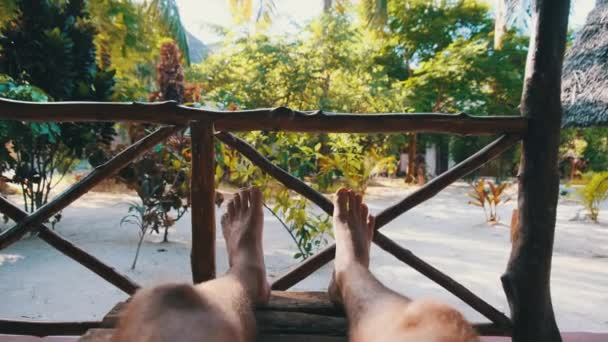 POV of Man Legs на веранде отеля, летние каникулы, Занзибар, Африка — стоковое видео