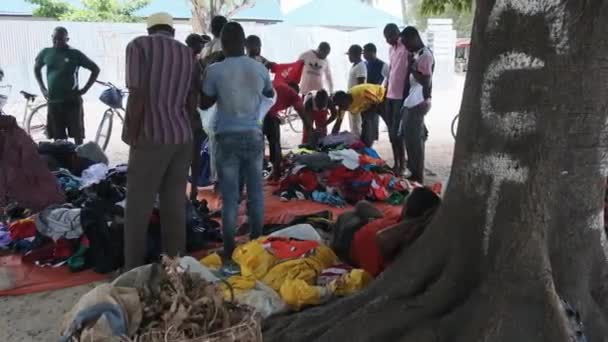 Afrikalılar Afrika, Zanzibar 'daki bir açık hava dükkanından ikinci el kıyafet satın alıyor. — Stok video