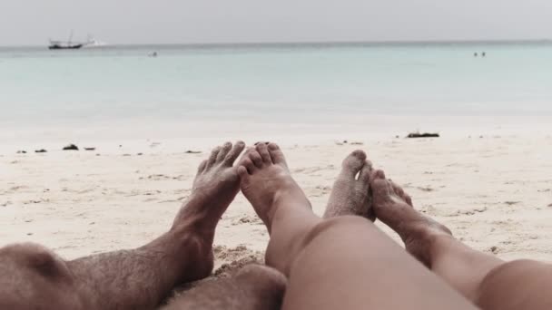 一对男女情侣在热带沙滩上的POV脚在海边躺着 — 图库视频影像