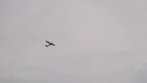 Легкомоторный самолет, летящий в небе среди облаков, вид снизу — стоковое видео