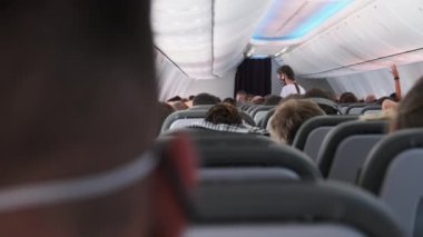 Uçuş sırasında Kol Sandalyelerinde Maskeli İnsanlar Oturan Yolcu Uçağı Kabini