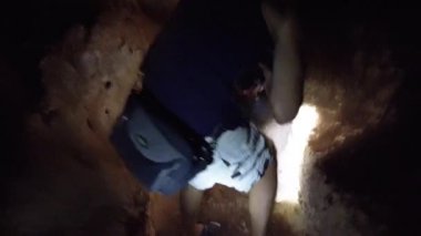 İnsan Karanlık Mağara 'nın İçindeki Stalactite' leri Keşfeder, El feneriyle Aydınlatır