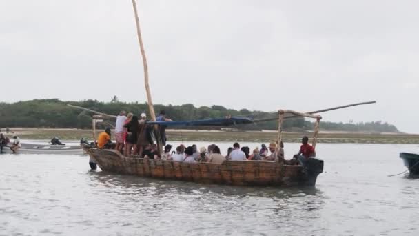 Turist kalabalığı okyanus kıyısında bir Afrika teknesinde yüzüyor, Zanzibar 'da. — Stok video