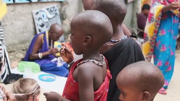 Místní africké hladové dítě jí papír na ulici mezi lidmi, Zanzibar, Afrika — Stock video