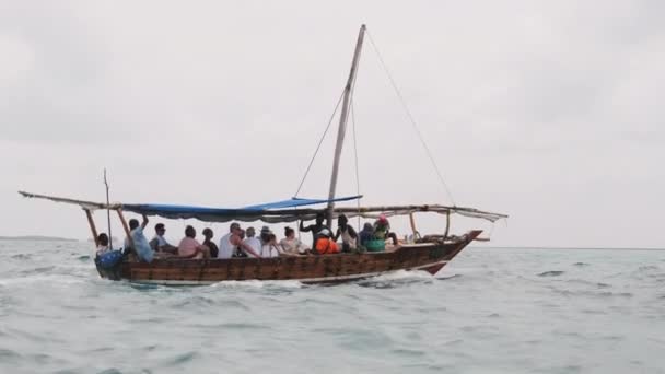 Toeristenmenigte drijft in een Afrikaanse boot door de oceaan op een excursie, Zanzibar — Stockvideo
