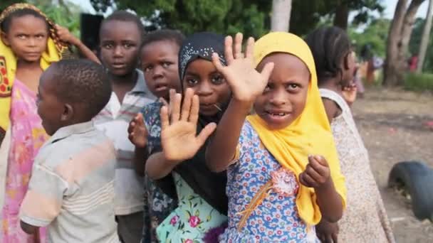 Veselé místní africké děti legrační mávání rukou a zvědavý vzhled, Zanzibar Village — Stock video