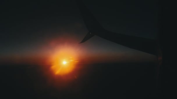 Vue de la fenêtre de l'avion au coucher du soleil, coucher de soleil orange sous l'aile de l'avion — Video