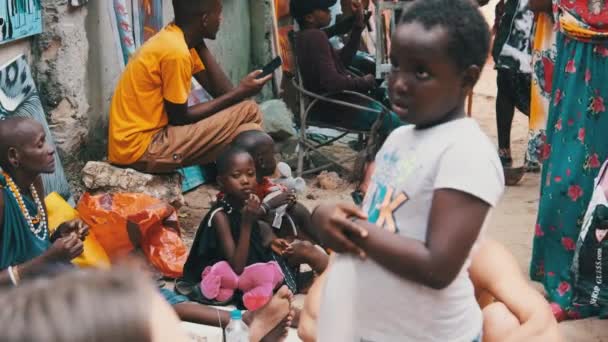 Lokalne głodne afrykańskie małe dzieci chodzić po ulicy wśród ludzi, Zanzibar — Wideo stockowe