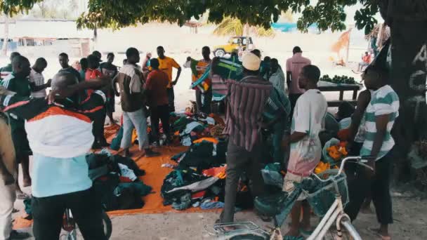 Afrikai emberek használt ruhát vesznek egy szabadtéri boltban Afrikában, Zanzibárban — Stock videók