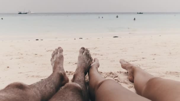 Piedi POV di un paio di uomini e donne sdraiati su una spiaggia di sabbia tropicale di Oceano — Video Stock