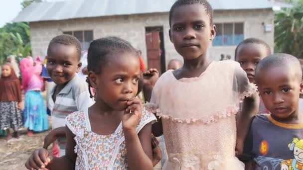 Местные африканские дети с любопытством смотрят в камеру в деревне Занзибар, Африка — стоковое видео