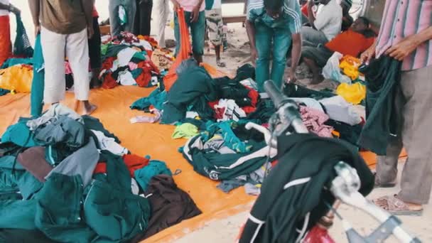 African People Buy Second-Hand Clothing on an Open-Air Shop in Africa, Zanzibar — Stock Video