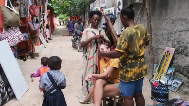 Afrikanische Frauen weben afrikanische Zöpfe an Touristen im Freien, Sansibar Afrika — Stockvideo