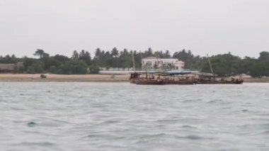 Turist kalabalığı okyanus kıyısında bir Afrika teknesinde yüzüyor, Zanzibar 'da.
