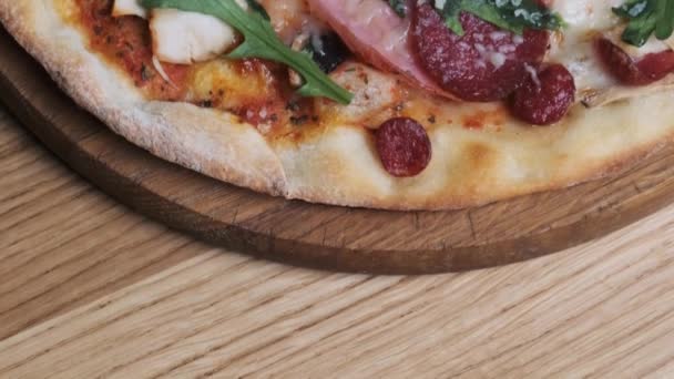 Ορεκτική πίτσα σε ένα ξύλινο πίνακα σε ένα εστιατόριο — Αρχείο Βίντεο