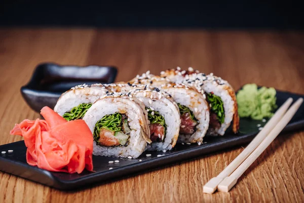 Restoranda ahşap bir masada suşi, lezzetli Japon yemekleri, suşi ruloları.