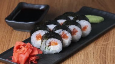 Restoranda ahşap bir masada suşi, lezzetli Japon yemekleri, suşi ruloları.