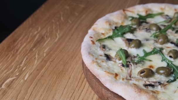 Aptitretare pizza på ett träbord i en restaurang — Stockvideo