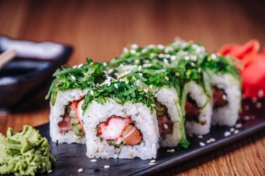 Restoranda ahşap bir masada suşi, lezzetli Japon yemekleri, suşi ruloları.
