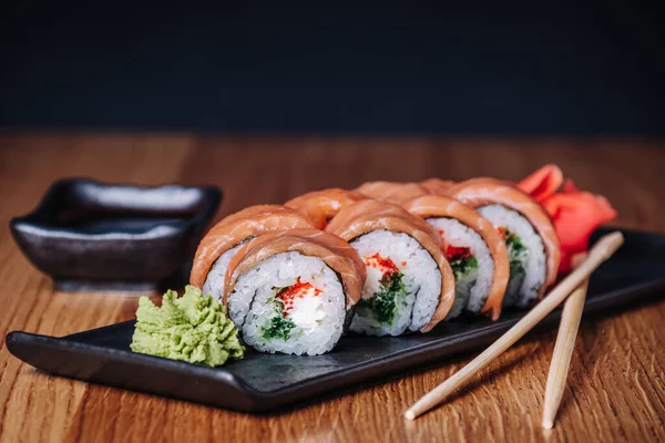 Restoranda ahşap bir masada suşi, lezzetli Japon yemekleri, suşi ruloları.