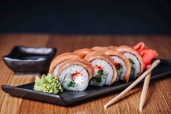 Restoranda ahşap bir masada suşi, lezzetli Japon yemekleri, suşi ruloları.