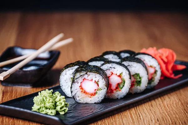 Restoranda ahşap bir masada suşi, lezzetli Japon yemekleri, suşi ruloları.
