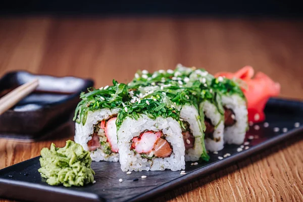 Restoranda ahşap bir masada suşi, lezzetli Japon yemekleri, suşi ruloları.