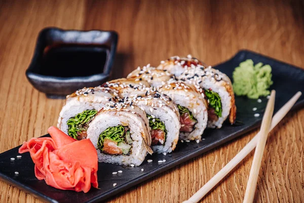 Restoranda ahşap bir masada suşi, lezzetli Japon yemekleri, suşi ruloları.