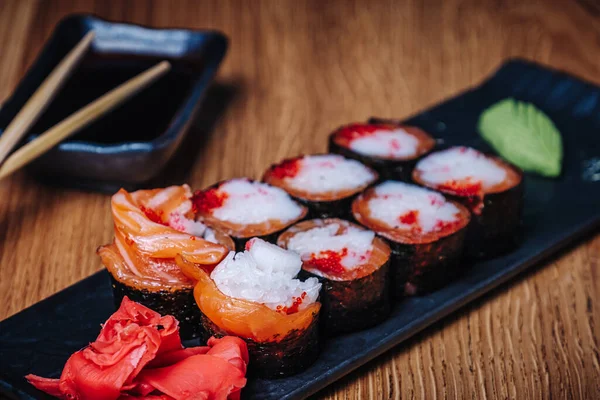 Restoranda ahşap bir masada suşi, lezzetli Japon yemekleri, suşi ruloları.
