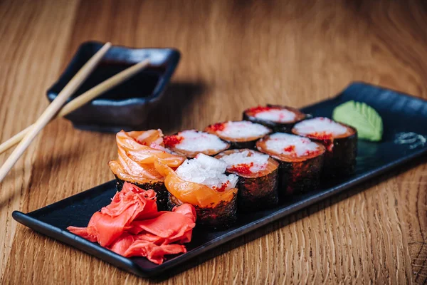 Restoranda ahşap bir masada suşi, lezzetli Japon yemekleri, suşi ruloları.