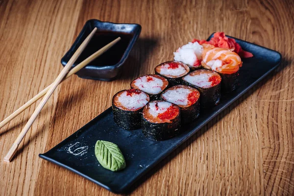 Restoranda ahşap bir masada suşi, lezzetli Japon yemekleri, suşi ruloları.