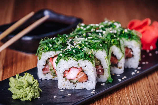 Restoranda ahşap bir masada suşi, lezzetli Japon yemekleri, suşi ruloları.