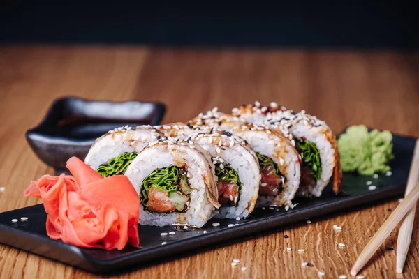 Restoranda ahşap bir masada suşi, lezzetli Japon yemekleri, suşi ruloları.