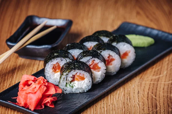 Restoranda ahşap bir masada suşi, lezzetli Japon yemekleri, suşi ruloları.