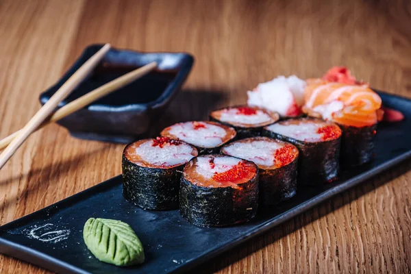 Restoranda ahşap bir masada suşi, lezzetli Japon yemekleri, suşi ruloları.
