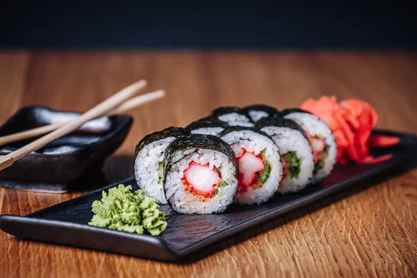 Restoranda ahşap bir masada suşi, lezzetli Japon yemekleri, suşi ruloları.