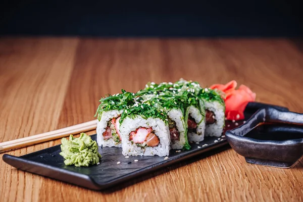 Restoranda ahşap bir masada suşi, lezzetli Japon yemekleri, suşi ruloları.