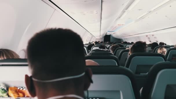 Кабіна пасажирського літака з маскованими людьми сидить у кріслах під час польоту — стокове відео