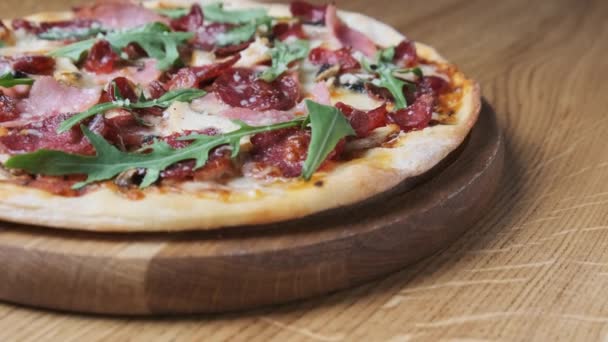 Pizza apetecible en una mesa de madera en un restaurante — Vídeo de stock