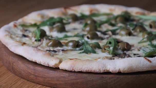 Pizza étvágygerjesztő egy fából készült asztalon egy étteremben — Stock videók