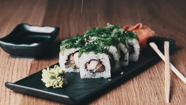 Sushi mit Sesamsamen auf Holztisch im Restaurant streuen — Stockvideo