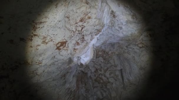 Erkunden Sie eine tiefe dunkle Höhle mit Stalaktiten im Licht einer Laterne, Afrika — Stockvideo