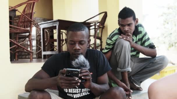 Местный житель Африки записывает блог на камеру с помощью телефона и микрофона — стоковое видео