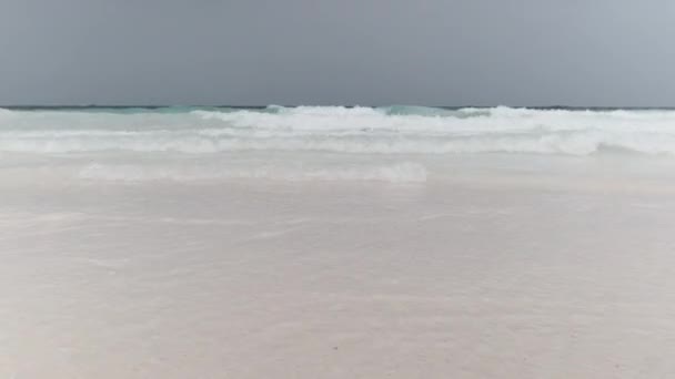 Krajobraz pięknej plaży tropikalnej z falami przypływowymi i błękitnym niebem, Zanzibar — Wideo stockowe