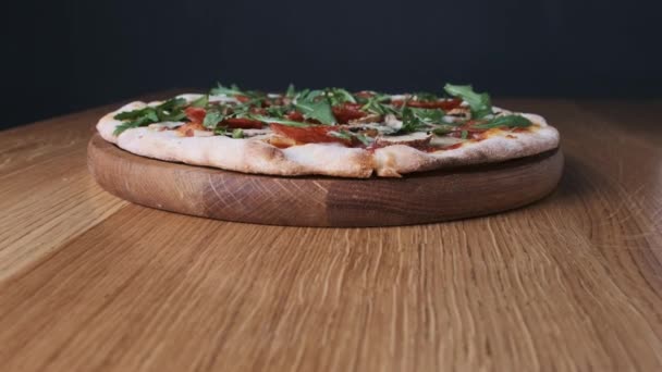 Pizza apetecible en una mesa de madera en un restaurante — Vídeo de stock